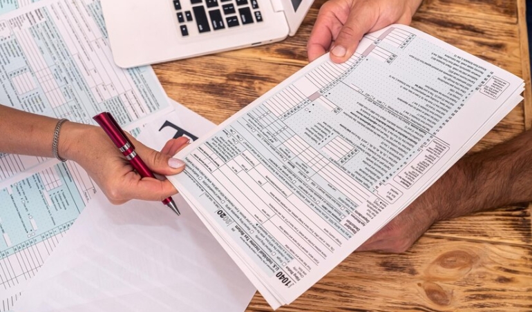 two-employees-work-fill-out-tax-forms-1040-office-desk_359031-25099
